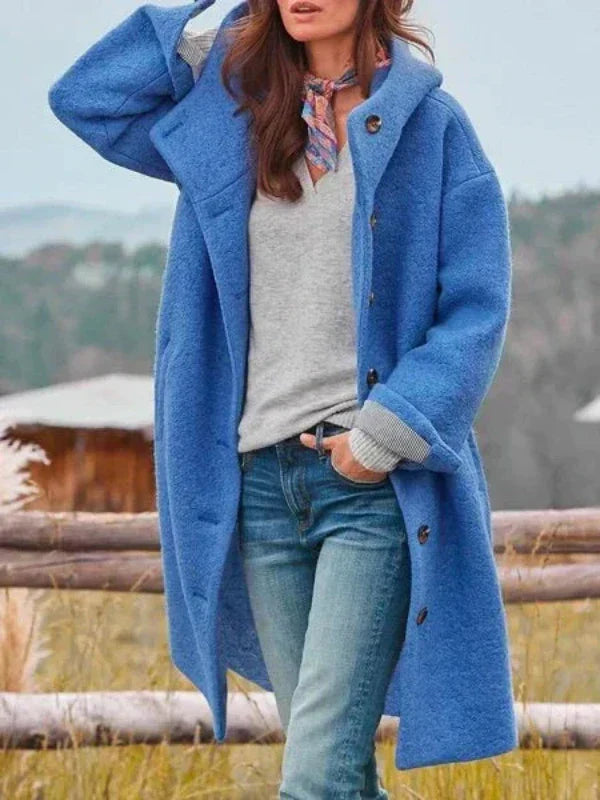 Donna con cappotto blu oversize, maglione grigio, jeans, e foulard colorato. Moda autunnale, abbigliamento casual elegante all'aperto.
