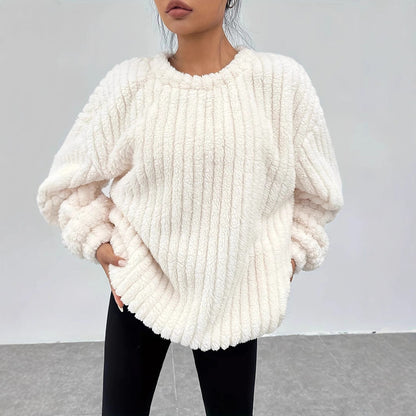 Donna con maglione bianco in pelliccia sintetica, design a coste, maniche lunghe, abbinato a pantaloni neri. Moda autunnale, stile casual chic.