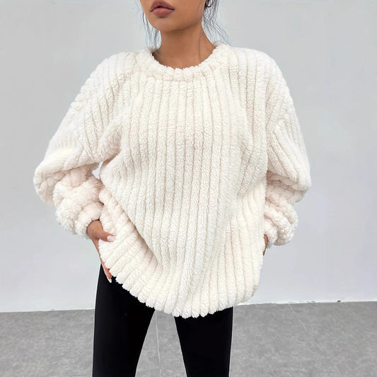 Donna con maglione bianco in pelliccia sintetica, design a coste, maniche lunghe, abbinato a pantaloni neri. Moda autunnale, stile casual chic.