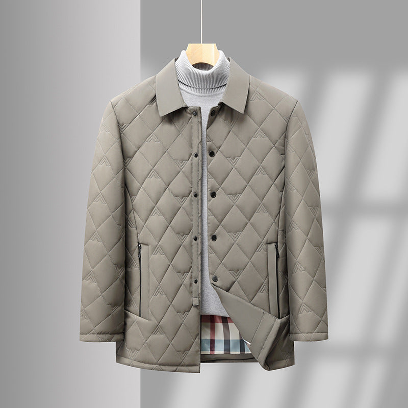 Giacca trapuntata beige su sfondo grigio, appesa su gruccia. Design elegante, bottoni frontali, ideale per moda autunnale e invernale.