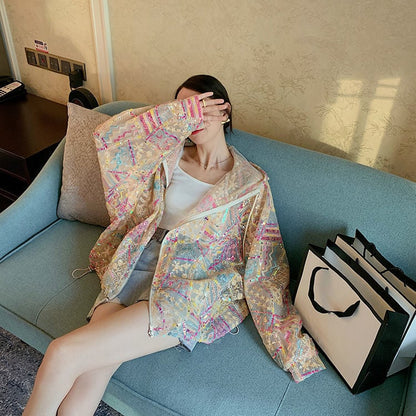 Donna seduta su divano blu indossa giacca colorata e copre il viso con la mano; accanto a lei, borse shopping bianche. Moda casual, relax.