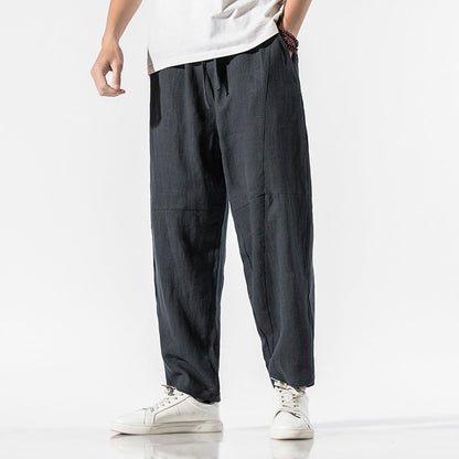 Pantaloni larghi uomo in lino nero, stile casual, abbinati a scarpe bianche. Moda maschile estiva, abbigliamento comodo e traspirante.