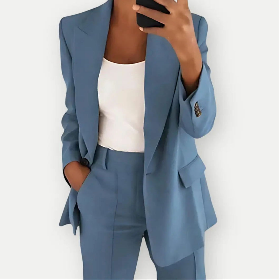 Donna in abito elegante blu, giacca e pantaloni coordinati, con top bianco. Moda business casual, outfit professionale, stile moderno.