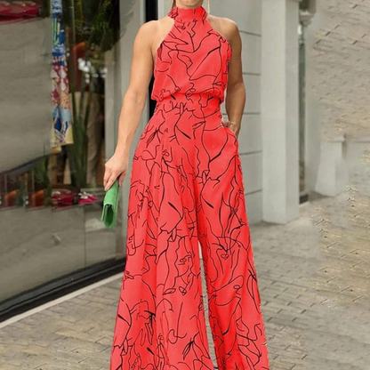 Donna in tuta rossa con motivo astratto nero, borsa verde, davanti a una vetrina. Moda elegante, abbigliamento estivo, stile contemporaneo.