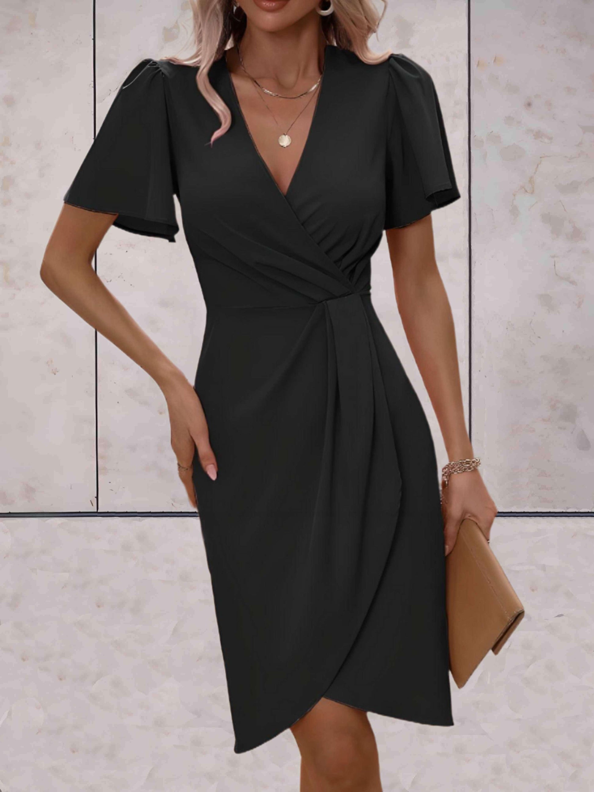 Abito nero elegante da donna con scollo a V e maniche corte, indossato con accessori dorati e pochette beige. Moda femminile, abbigliamento chic.
