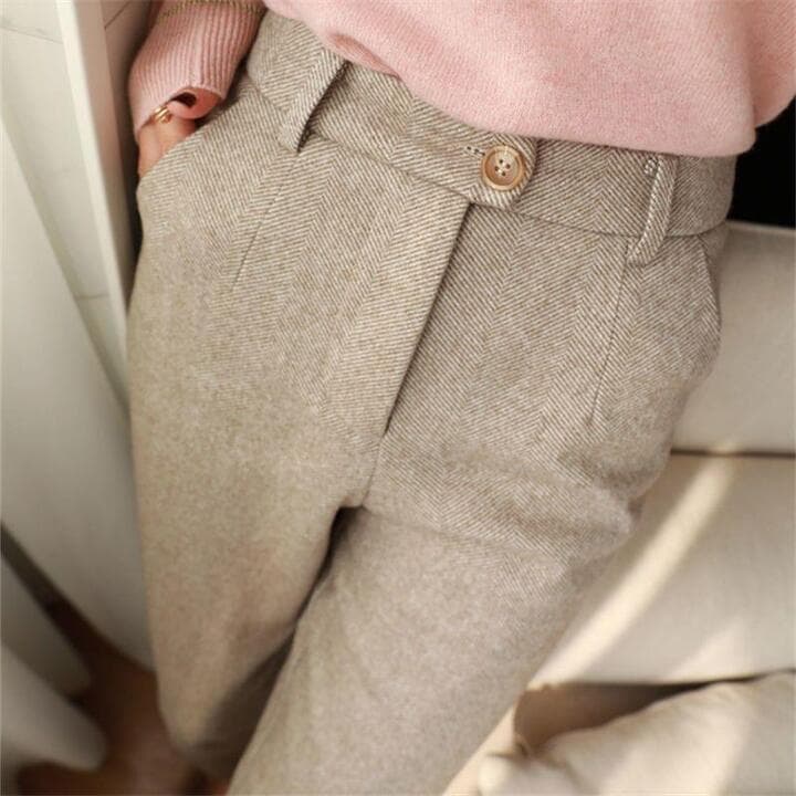 Pantaloni eleganti in tessuto spigato beige, abbinati a maglione rosa. Moda autunnale, abbigliamento casual chic per donna.