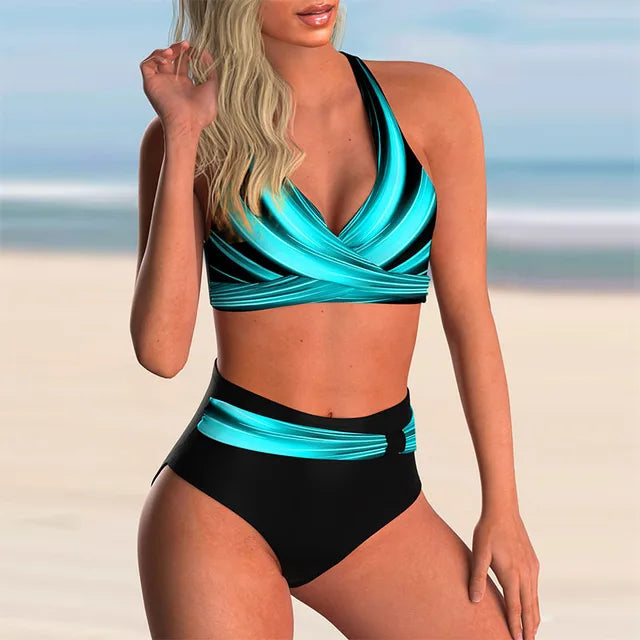Donna in costume da bagno a due pezzi blu e nero su spiaggia sabbiosa. Moda mare, bikini estivo, abbigliamento da spiaggia elegante.