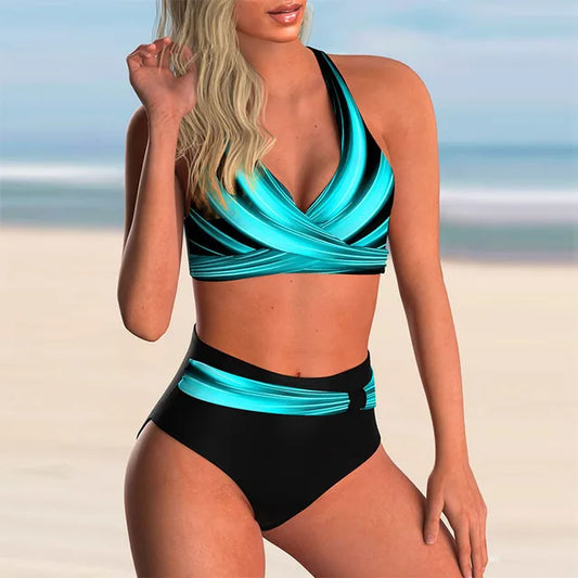 Donna in costume da bagno a due pezzi blu e nero su spiaggia sabbiosa. Moda mare, bikini estivo, abbigliamento da spiaggia elegante.