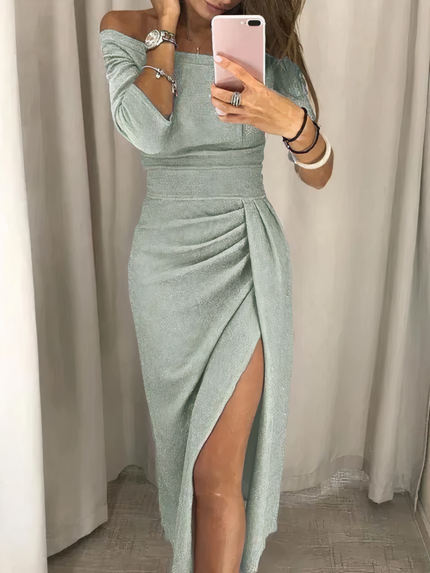Abito elegante verde menta con spacco laterale, maniche a tre quarti, indossato da donna che si specchia. Moda femminile, stile sofisticato.