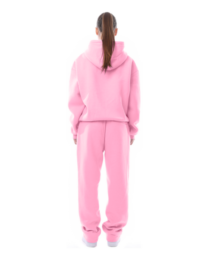 Donna in tuta rosa, vista posteriore. Abbigliamento sportivo casual, felpa con cappuccio e pantaloni, moda streetwear femminile.