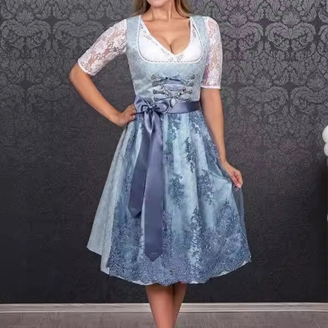 Donna in abito tradizionale dirndl blu con dettagli in pizzo bianco, sfondo decorativo grigio. Moda bavarese, abbigliamento tradizionale tedesco.