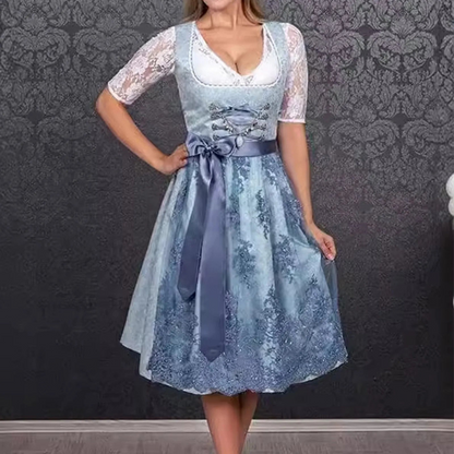 Donna in abito tradizionale dirndl blu con dettagli in pizzo bianco, sfondo decorativo grigio. Moda bavarese, abbigliamento tradizionale tedesco.