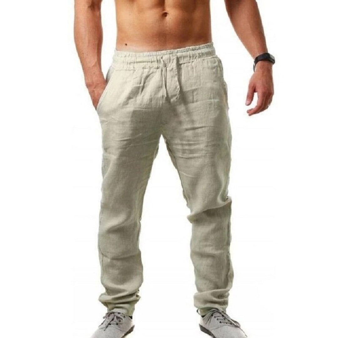 Pantaloni uomo in lino beige, stile casual, con tasche laterali. Ideali per look estivo, abbinati a scarpe sportive grigie.