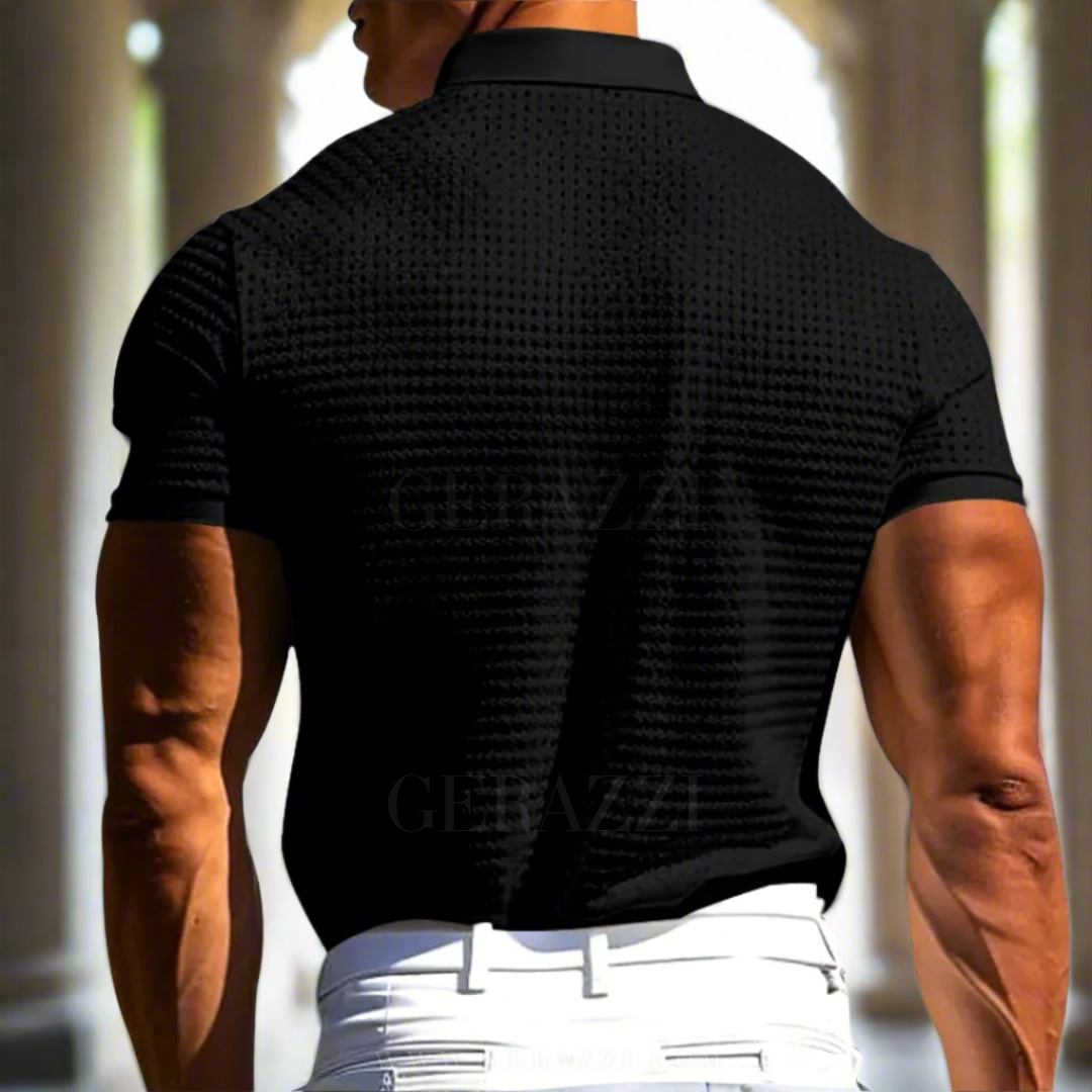 Uomo muscoloso in polo nera elegante, tessuto a trama, pantaloni bianchi, sfondo colonne classiche. Moda maschile, abbigliamento estivo.