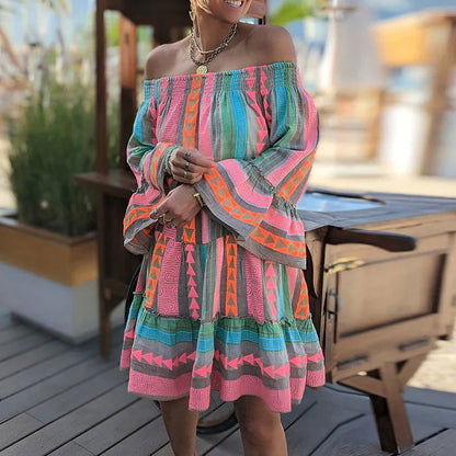 Abito estivo colorato con motivi geometrici, maniche lunghe e scollo a barca, indossato da una donna all'aperto. Moda estiva, abbigliamento casual.