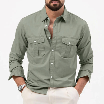 Camicia verde militare da uomo con tasche frontali, maniche lunghe e bottoni, indossata con pantaloni chiari. Stile casual elegante.