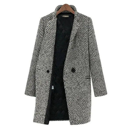 Cappotto donna elegante in tweed bianco e nero, doppio petto, con fodera interna nera, appeso su gruccia di legno. Moda autunno inverno.