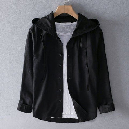 Camicia nera con cappuccio, appesa su gruccia, sopra maglietta bianca. Moda casual uomo, abbigliamento autunnale, stile urbano.