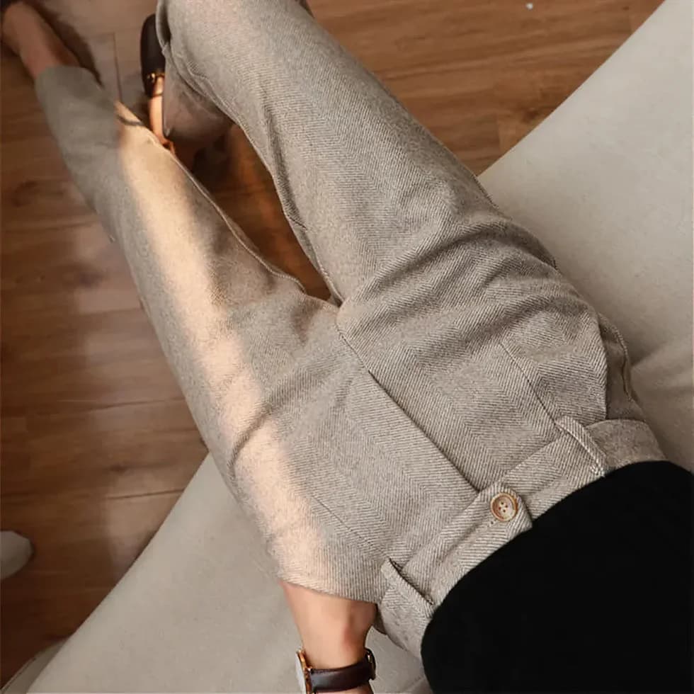 Pantaloni eleganti in tessuto grigio chiaro, stile formale, su sfondo di pavimento in legno. Ideali per moda uomo, abbigliamento business casual.