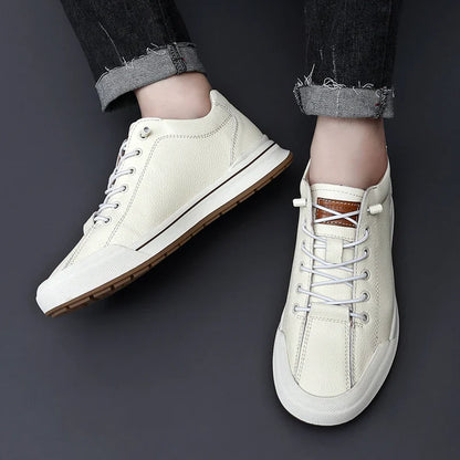Scarpe da ginnastica bianche in pelle, suola in gomma marrone, indossate con jeans neri. Design casual e moderno, perfette per moda urbana.