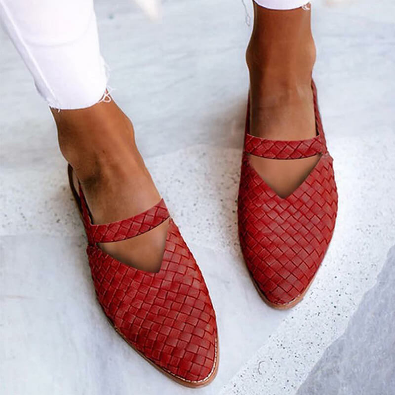 Scarpe rosse intrecciate in pelle, indossate con jeans bianchi. Design elegante e moderno, perfetto per moda estiva e look casual chic.