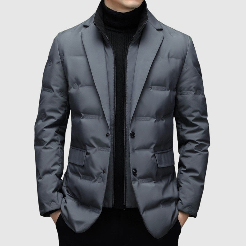 Giacca invernale uomo grigia elegante, imbottita, con chiusura a bottoni, indossata sopra maglione nero. Moda maschile, abbigliamento caldo.