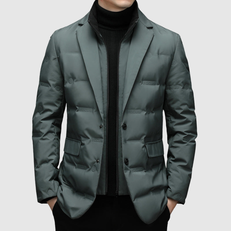 Giacca imbottita uomo elegante, colore grigio scuro, con bottoni e tasche, indossata sopra maglione nero. Moda invernale maschile.