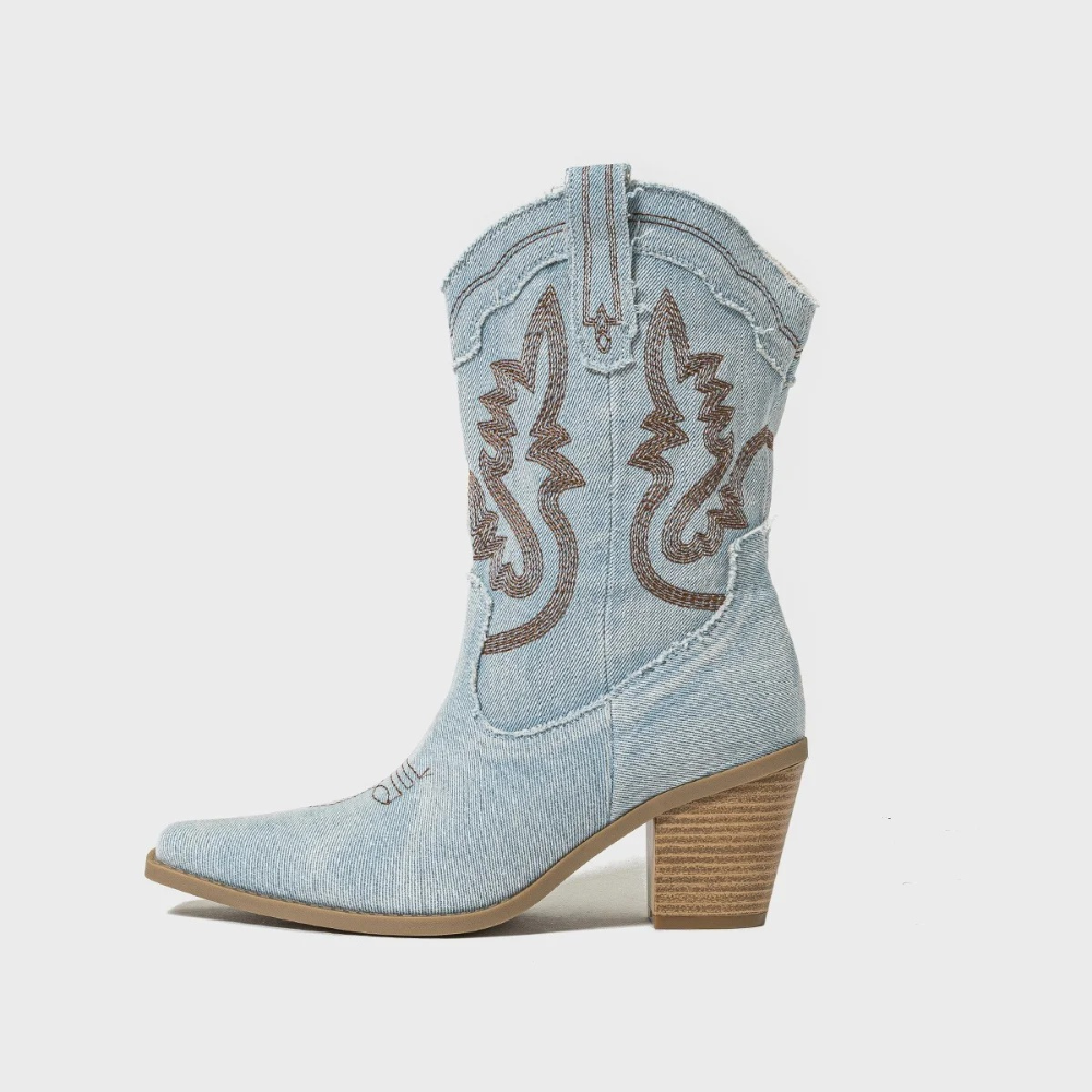 Stivale western in denim chiaro con tacco alto in legno, dettagli ricamati marroni, punta affusolata. Moda country, calzature donna eleganti.