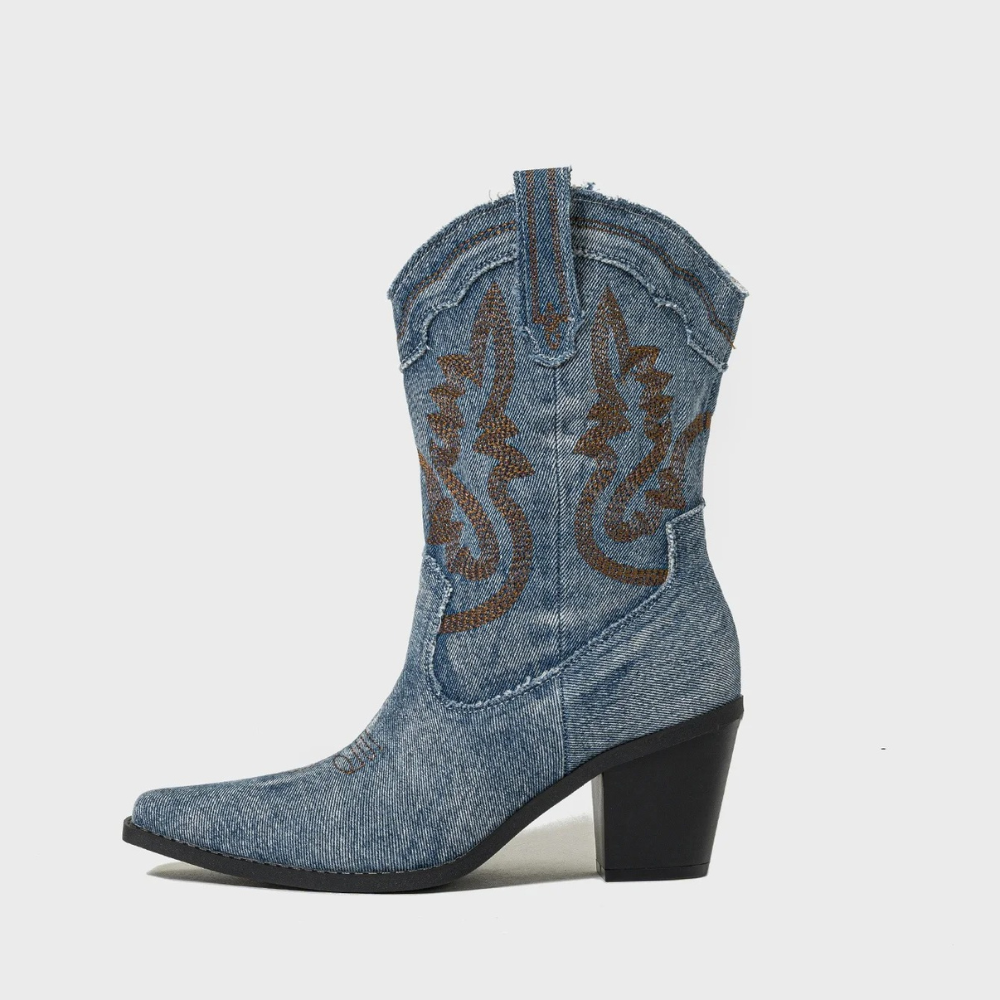 Stivale texano in denim blu con ricami marroni, tacco alto e punta affusolata. Calzature western moda donna, stile country chic.