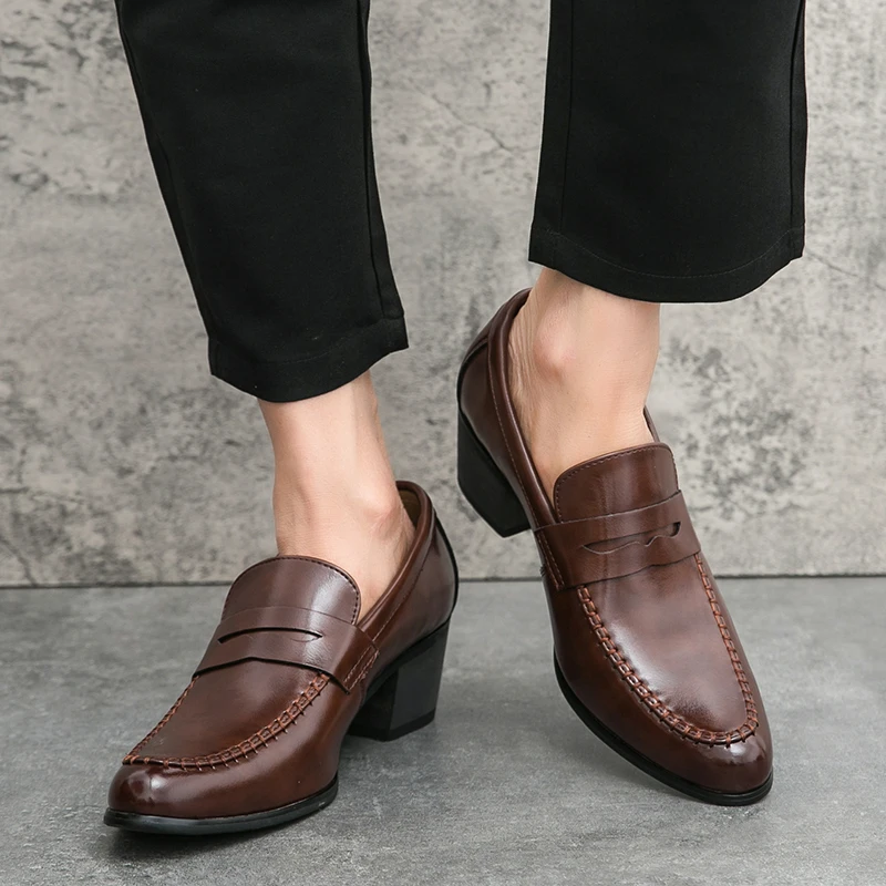 Scarpe mocassini uomo in pelle marrone, eleganti e classiche, indossate con pantaloni neri. Calzature moda maschile, stile formale e raffinato.