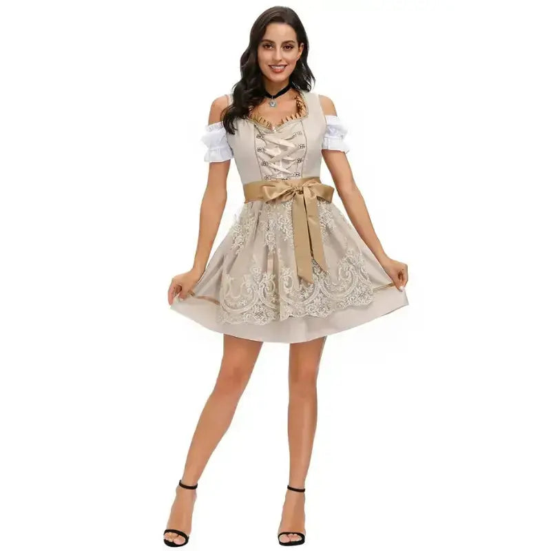 Donna in abito tradizionale bavarese beige con dettagli in pizzo e fiocco, spalle scoperte, scarpe nere con tacco. Moda Oktoberfest elegante.