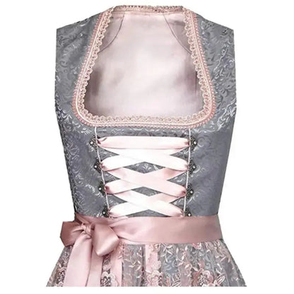 Dirndl tradizionale grigio con dettagli in pizzo rosa, corsetto con nastri incrociati e fiocco in vita. Abito bavarese elegante per Oktoberfest.