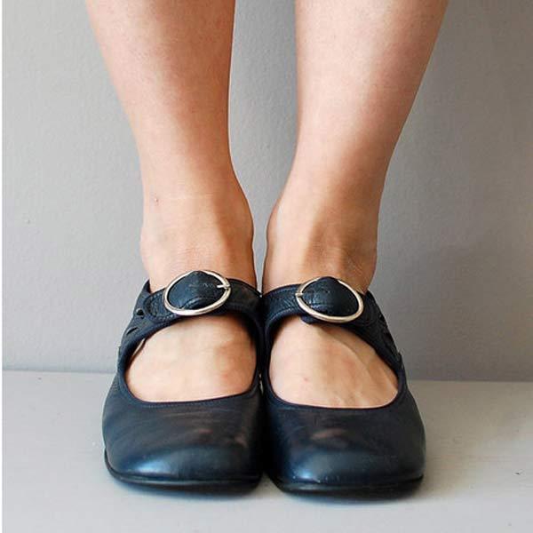 Scarpe Mary Jane nere con fibbia, indossate su piedi femminili. Calzature eleganti e comode, ideali per moda casual e look quotidiano.