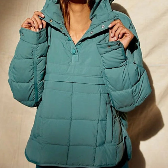 Giacca invernale imbottita verde acqua con cappuccio, design trapuntato, chiusura a bottoni, ideale per moda donna e abbigliamento outdoor.