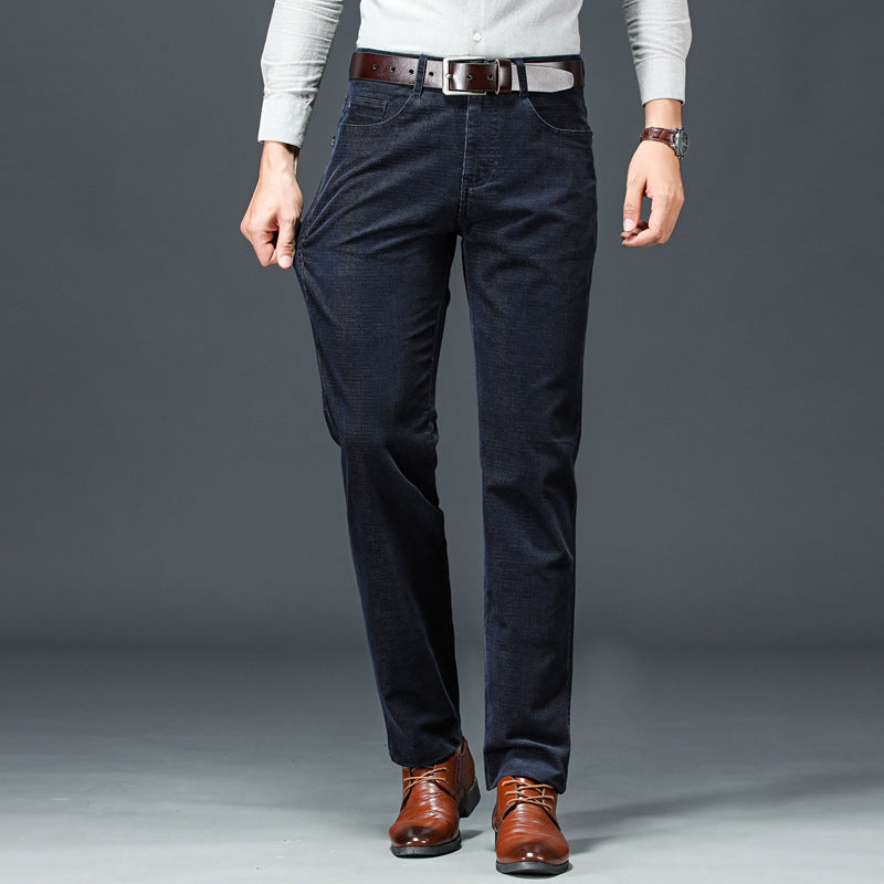 Uomo in pantaloni di velluto a coste blu scuro, camicia grigia e scarpe marroni eleganti. Moda maschile autunnale, abbigliamento casual chic.