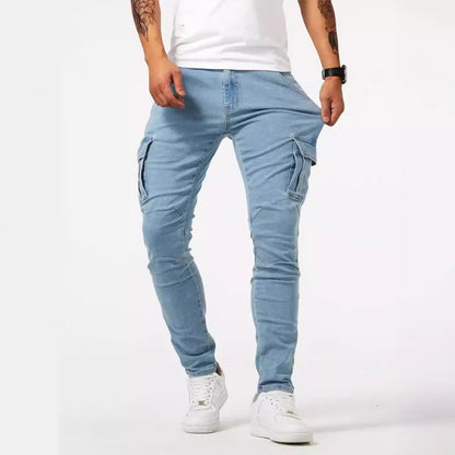 Jeans cargo uomo azzurri, tasche laterali, indossati con t-shirt bianca e sneakers bianche. Stile casual, moda maschile contemporanea.