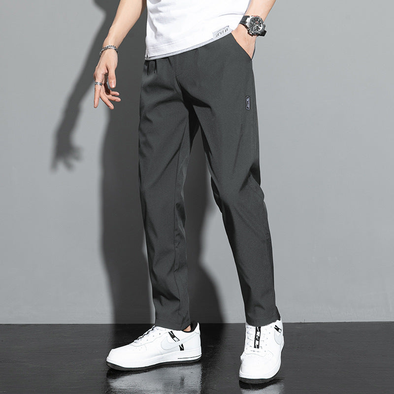 Pantaloni neri da uomo eleganti, abbinati a scarpe da ginnastica bianche e t-shirt bianca. Moda casual maschile, stile moderno e raffinato.