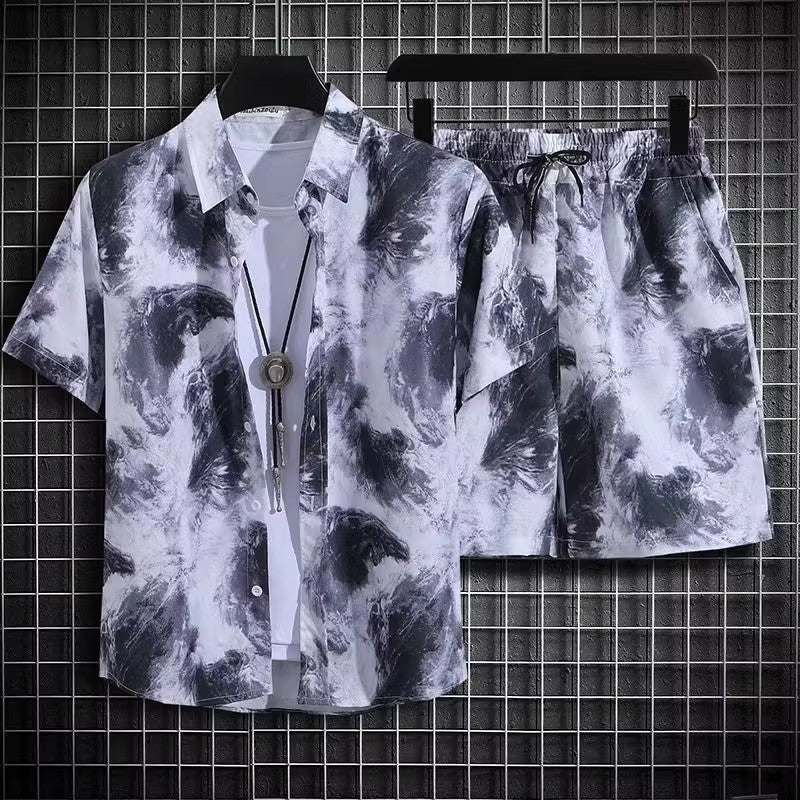 Completo estivo uomo, camicia e pantaloncini, motivo tie-dye bianco e nero, stile casual, appeso su griglia metallica.
