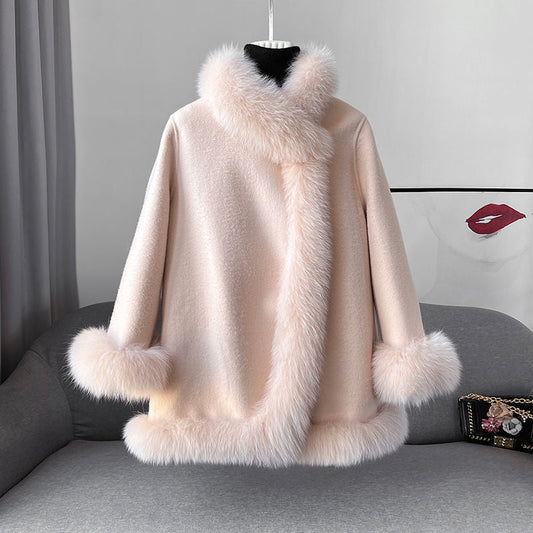 Cappotto invernale elegante color crema con bordo in pelliccia sintetica, appeso su manichino. Moda donna, abbigliamento caldo, stile sofisticato.