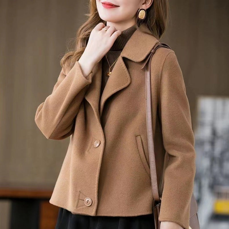 Donna con cappotto marrone elegante, collo alto, orecchini dorati, borsa a tracolla. Moda autunnale, abbigliamento femminile chic.
