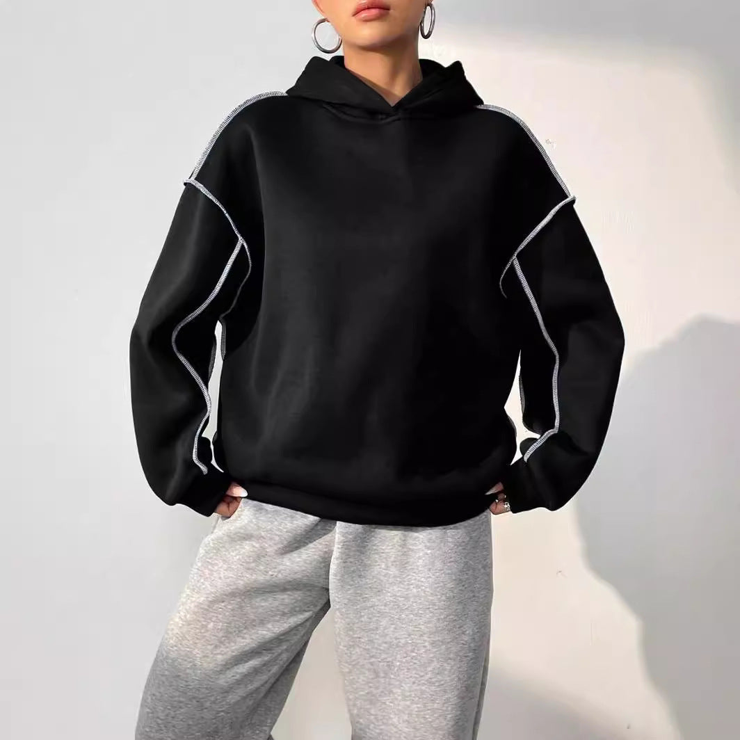 Donna con felpa nera oversize e pantaloni grigi, moda casual autunno, abbigliamento streetwear, stile urbano, tendenze abbigliamento 2023.