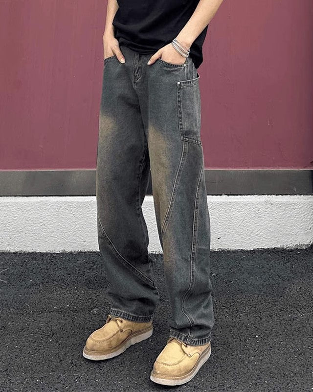 Jeans larghi grigi da uomo, stile casual, con scarpe beige su sfondo rosso. Moda streetwear, pantaloni oversize, tendenza abbigliamento urbano.