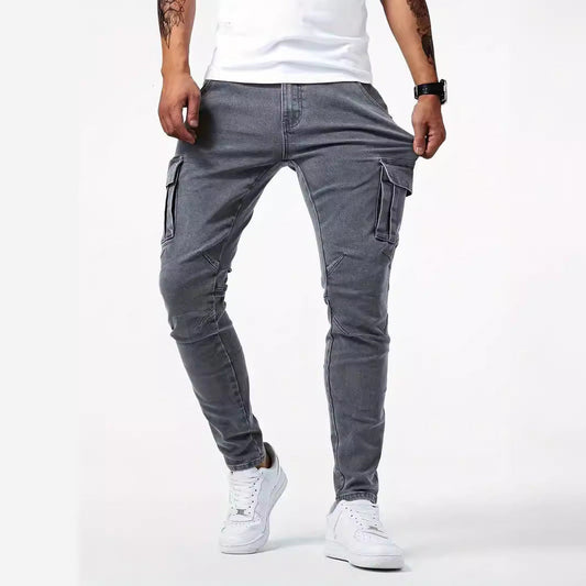 Jeans cargo grigi da uomo, vestibilità slim, tasche laterali, abbinati a scarpe da ginnastica bianche e maglietta bianca.