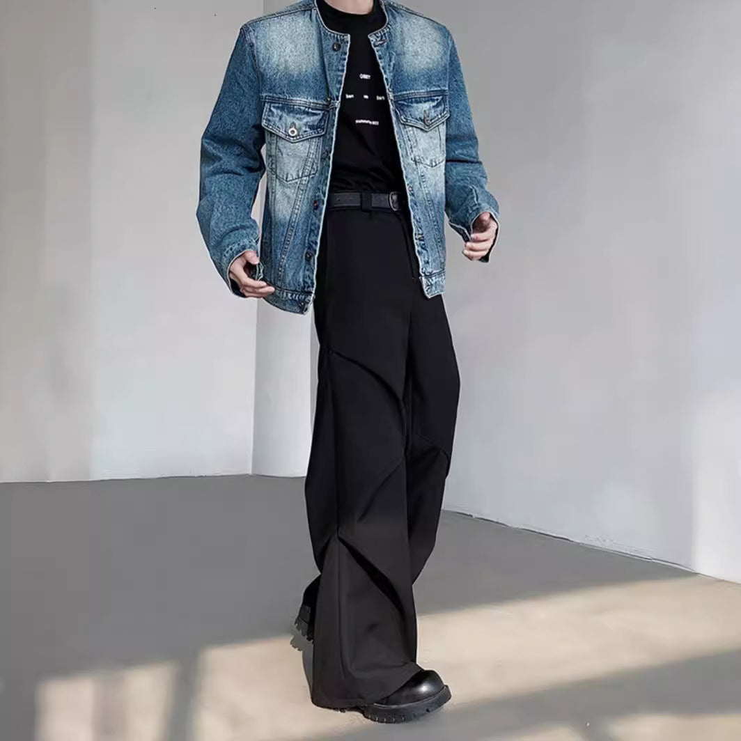 Uomo con giacca di jeans e pantaloni neri larghi, scarpe nere. Moda casual maschile, stile urbano, abbigliamento moderno.