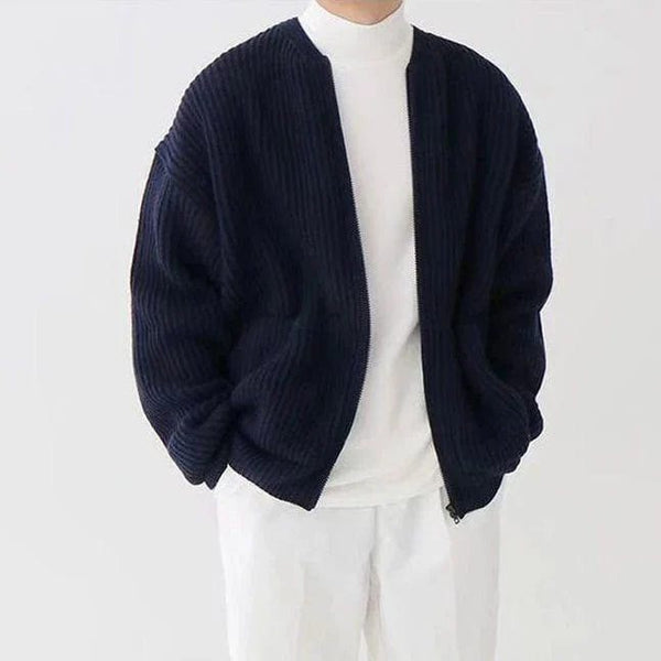 Giacca cardigan blu scuro a coste su uomo con maglia bianca e pantaloni bianchi. Moda maschile elegante, abbigliamento casual autunnale.