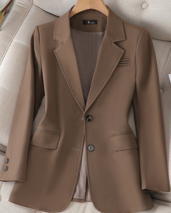 Giacca elegante marrone da donna su appendiabiti, con due bottoni e tasche frontali, perfetta per abbigliamento formale e business casual.