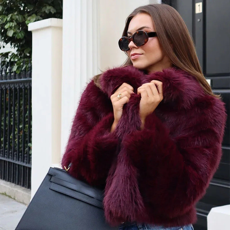 Donna con cappotto di pelliccia bordeaux, occhiali da sole neri e borsa elegante. Moda autunnale, stile urbano chic.