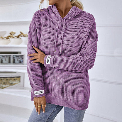 Maglione viola a maglia grossa con cappuccio, indossato da una persona in jeans. Design casual, ideale per moda autunnale e invernale.
