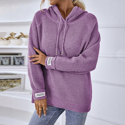 Maglione viola a maglia grossa con cappuccio, indossato da una persona in jeans. Design casual, ideale per moda autunnale e invernale.