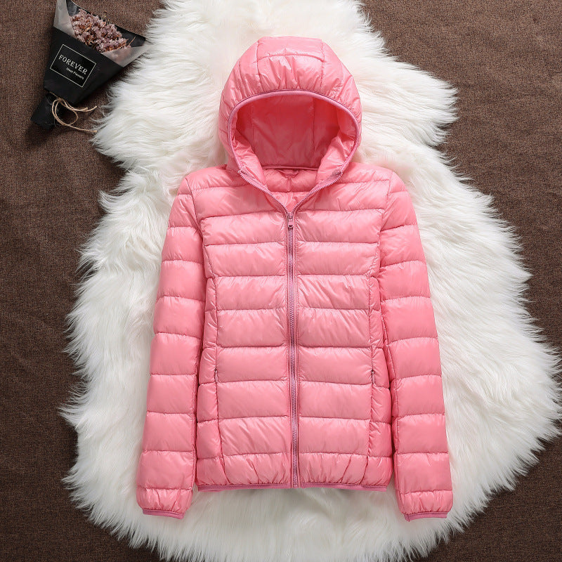 Giacca invernale rosa con cappuccio su sfondo di pelliccia bianca, design trapuntato, chiusura a zip, moda donna, abbigliamento caldo e casual.